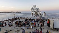 Migrantes ajudados a desembarcar do navio da Guarda Costeira Italiana, Diciotti, em Reggio Calabria, a 15 de março de 2023.