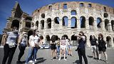 Tourists wear face masks to curb the spread of COVID-19 as they listen to a tour guide outside the ancient Colosseum, in Rome, May 21, 2021. 