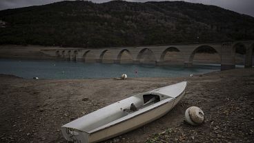 A stranded boat is pictured above the water line at the lake Serre-Poncon in southern France, Tuesday, March 14, 2023.