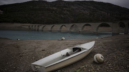 A stranded boat is pictured above the water line at the lake Serre-Poncon in southern France, Tuesday, March 14, 2023.