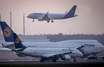 Ein Lufthansa-Flugzeug landet, während zwei andere auf dem Flughafen in Frankfurt am Main, Deutschland, warten, 3. März 2023.