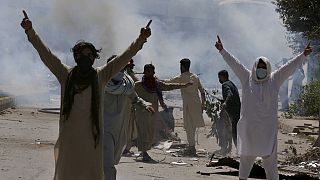 Supporters of Pakistan's former Prime Minister Imran Khan gestures as police fire tear gas to disperse them. Peshawar, May 10, 2023