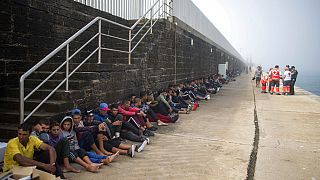 مهاجرون يجلسون في ميناء طريفة، جنوب إسبانيا، في انتظار نقلهم إلى مركز للشرطة، الأربعاء 16 أغسطس 2017 