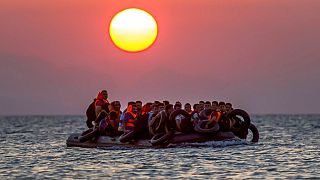 مهاجرون على متن زورق يصلون إلى جزيرة كوس جنوب شرق اليونان بعد عبورهم من تركيا، يوم الخميس 13 أغسطس 2015. 