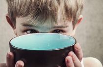 A child with an empty bowl,.