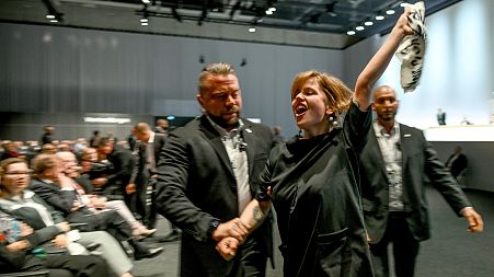 Climate activists are taken out of the venue of the annual shareholders' meeting of the Volkswagen AG in Berlin.