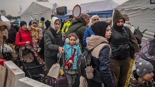 Ukrainian evacuees queue as they wait for further transport at the Medyka border crossing on March 29 2022