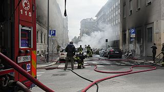Firefighters work to extinguish a fire in a building after a van exploded in central Milan, northern Italy, Thursday, May 11, 2023. 