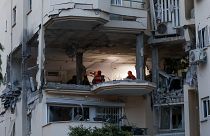 La police et les forces de secours sur les lieux où une roquette tirée de Gaza a touché et endommagé un bâtiment à Rehovot