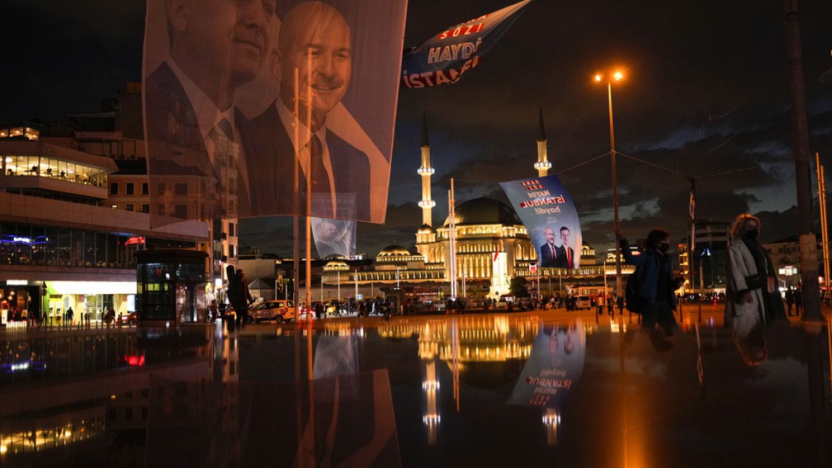 A giant banner of presidential candidates Recep Tayyip Erdogan, left, and Kemal Kilicdaroglu, background right, at Taksim square in Istanbul, Turkey, Wednesday, May 10, 2023. 