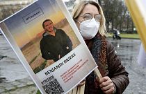 FILE - A woman holds a photo of Benjamin Briere during a rally in Paris, France, Saturday, Jan. 8, 2022. 