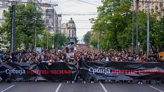 People hold banners with writing reading: "Serbia against violence" during a march against violence in Belgrade, Serbia, Friday, May 12, 2023.