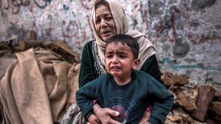 رعب يتملك بطفل فلسطيني ووالدته إثر القصف الإسرائيلي على بيت لاهيا شمال قطاع غزة. 2023/05/13