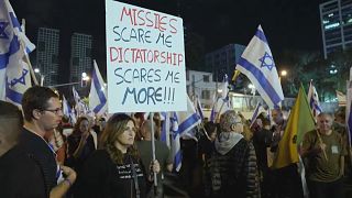 "Mísseis assustam-me. Ditadura assusta-me mais!", lê-se num cartaz durante manifestação em Telavive, Israel