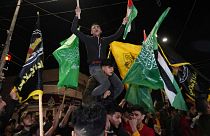 Palestinians celebrate the announcement of a cease-fire after five days of fighting