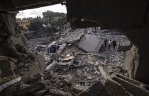 فلسطينيون يتفقدون الأنقاض في موقع غارة جوية قال الجيش الإسرائيلي إنها استهدفت منزل أحد أعضاء الجهاد الإسلامي في دير البلح. 2023/05/13
