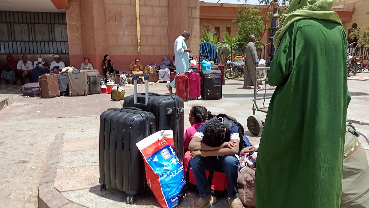 فارون من السودان الذي مزقته الحرب ينتظرون في محطة سكة حديد في مدينة أسوان المصرية. 2023/04/28