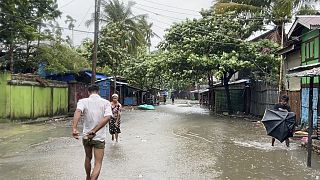 سكان محليون يسيرون في شارع غمرته المياه بسبب الأمطار الغزيرة مع اقتراب إعصار موكا في سيتوي، ولاية راخين، ميانمار، الأحد 14 مايو 2023.