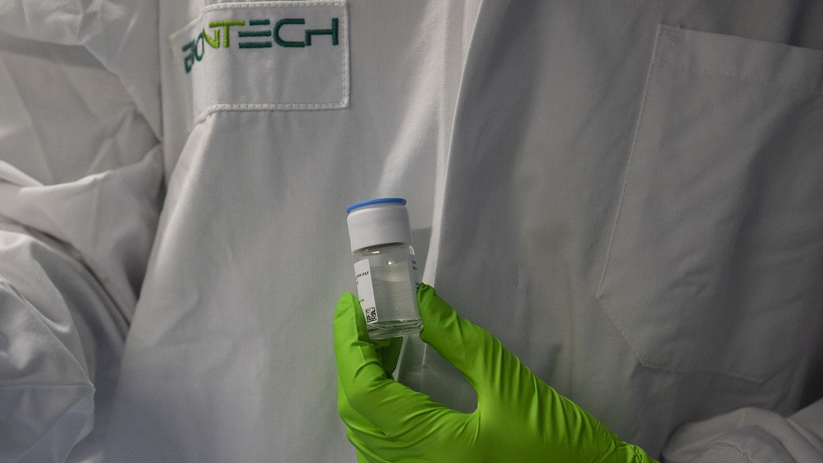 باحث يحمل قنينة من أحد منتجات الأورام قيد التطوير في معهد أبحاث شركة "بيونتيك" الألمانية