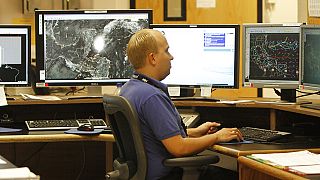 عالم أرصاد جوية يدرس نماذج الكمبيوتر لأنماط الطقس في المركز الوطني للأعاصير التابع للإدارة الوطنية للمحيطات والغلاف الجوي في ميامي، 1 يونيو 2010.