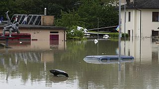 Vehicles are submerged in a flooded road, in Faenza, Italy.