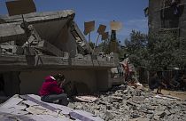 طفلة تجلس على أنقاض منزلها في غزة