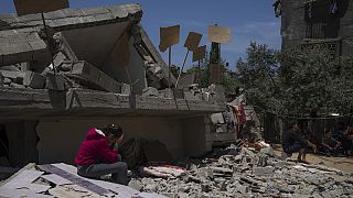 طفلة تجلس على أنقاض منزلها في غزة