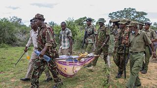 Rendőrök és helyi lakosok szállítják el az exhumált holttesteket Shakahola faluban
