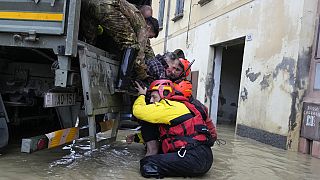 Firefighters rescue an elderly man in the flooded village of Castel Bolognese, Italy, Wednesday, May 17, 2023. 
