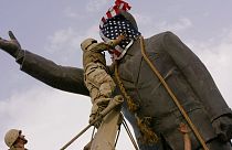 A statue of Saddam Hussein with an American flag before toppling in downtown Baghdad, Iraq, on April 9, 2003. C