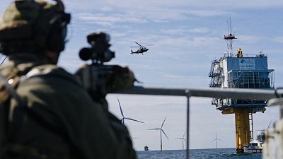 A sniper provides fire cover during a COASTEX security exercise at a wind farm in the North Sea, Belgium