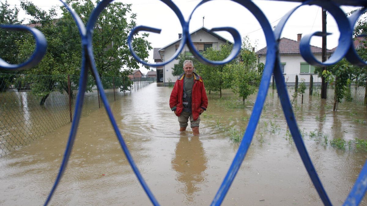 A Bosnian man stands in flooded water in front of his house in the village of Janja, near northern Bosnian town of Bijeljina, 130kms north east of Sarajevo.