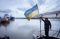 A sailor fixes the flag of Ukraine on a boat in Izmail, 700 km (432 miles) southwest of Kiev, Ukraine, on April 26, 2023.