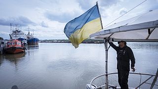A sailor fixes the flag of Ukraine on a boat in Izmail, 700 km (432 miles) southwest of Kiev, Ukraine, on April 26, 2023.