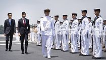 British Prime Minister Rishi Sunak and Japan's Vice Defense Minister Toshiro Ino inspect a guard of honour on board the Japanese aircraft carrier.