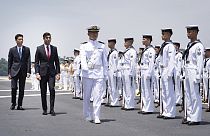 British Prime Minister Rishi Sunak and Japan's Vice Defense Minister Toshiro Ino inspect a guard of honour on board the Japanese aircraft carrier.