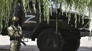 Ukrayna'daki Zaparojiya Nükleer Santrali önünde nöbet tutan bir Rus askeri ve üzerinde "Z" harfi bulunan bir askeri araç