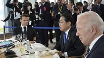 Macron francia és Biden amerikai elnök közt Fumio japán kormányfő