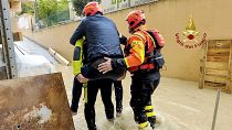 This photo provided by the Italian Firefighters shows firefighters rescuing a person from a flooded house in Riccione, Italy, Tuesday, May 16, 2023