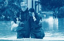 A couple walk in a flooded road of Lugo, Italy, 18 May 2023