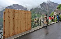 Une clôture provisoire en bois bloquait partiellement la vue magnifique, alors que les visiteurs prennent des selfies avec le paysage du village d'Hallstatt.