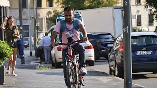 During the heatwave in Milan earlier this month, a surge in demand for home food deliveries pushed more delivery riders out into the heat.