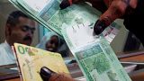 صورة من الارشيف-امرأة تحمل عملة سودانية في البنك المركزي بالخرطوم ، السودان
