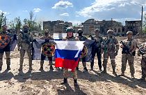 زعيم مجموعة فاغنز المسلحة الروسية يفغيني بريغوجين يحمل العلم الروسي أمام جنوده في باخموت بأوكرانيا، 20 مايو 2023