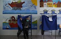 A man leaves the voting booth as he's votes at a polling station in Athens, Greece, Sunday, May 21, 2023.
