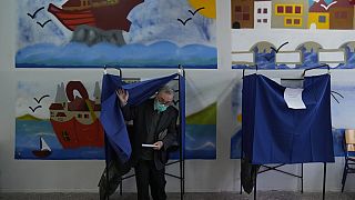 A man leaves the voting booth as he's votes at a polling station in Athens, Greece, Sunday, May 21, 2023.