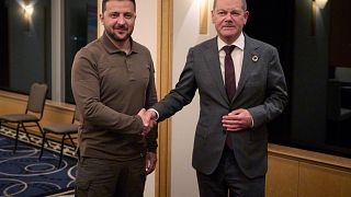 Volodimir Zelenszkij ukrán elnök és Olaf Scholz német kancellár kezet fog Hirosimában