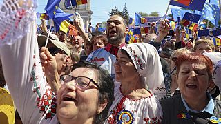 People with European Union flags and placards at a rally in Moldova. 