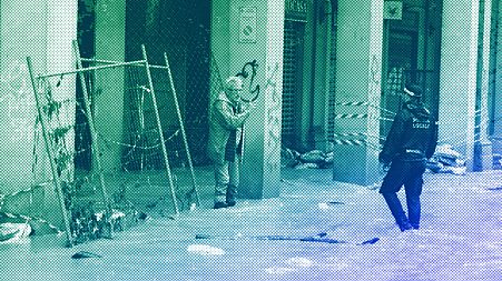 A man talks with a city police officer on a flooded street in Bologna, 17 May 2023