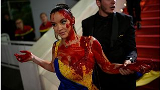إمرأة ترتدي ألوان أوكرانية، ملطخة بمادة حمراء في العرض الأول لفيلم "Acide" في مهرجان السينما الدولي السادس والسبعين، كان، فرنسا، الأحد 21 مايو/أيار 2023